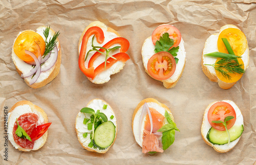Sandwiches with tasty cream cheese on parchment