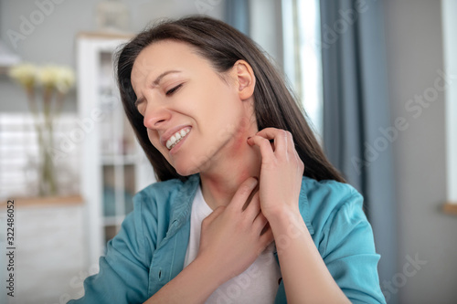 Woman itching her neck because of alergy Free Download Woman itching her neck because of alergy - GFXLoad