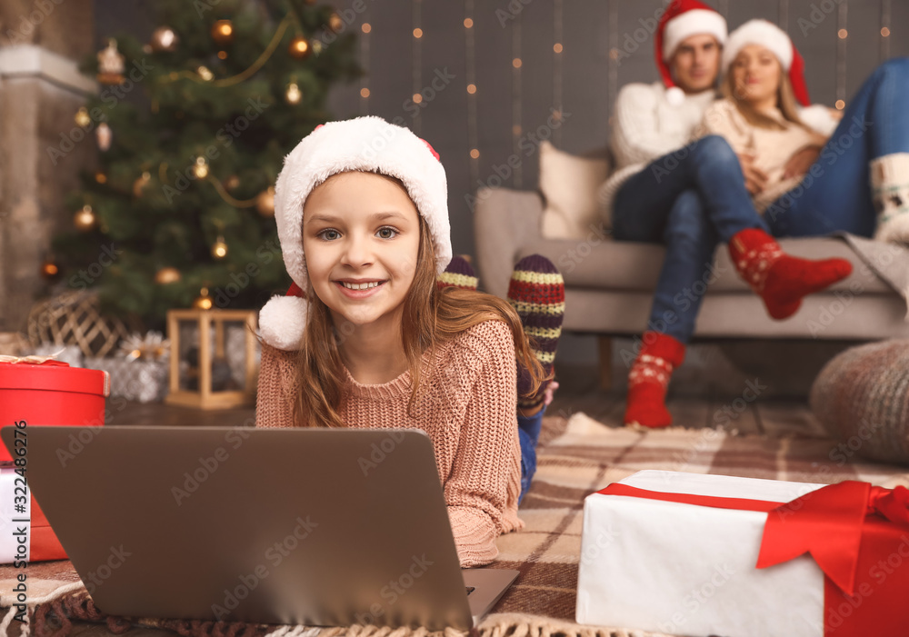 Little girl with laptop on Christmas eve at home Little girl with laptop on Christmas eve at home