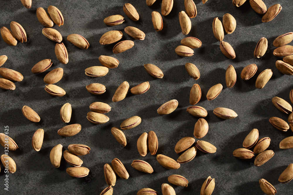 Pistachios on the black stone texture Pistachios on the black stone texture