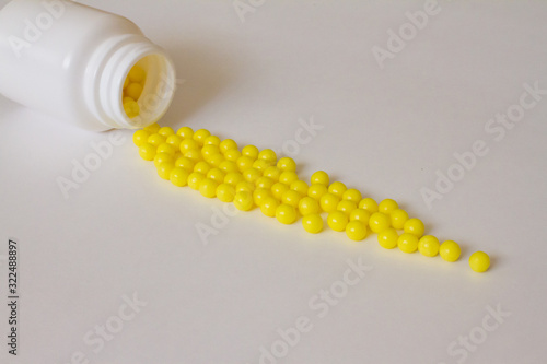 Yellow round tablets or vitamins in a white bubble, on a white background. Concept of medicine. Alternative homeopathy. Flatley. The view from the top. copyright for text.