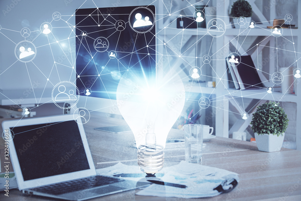 Computer on desktop in office with bulb icon hologram. Multi exposure. Concept of idea. Computer on desktop in office with bulb icon hologram. Multi exposure. Concept of idea.