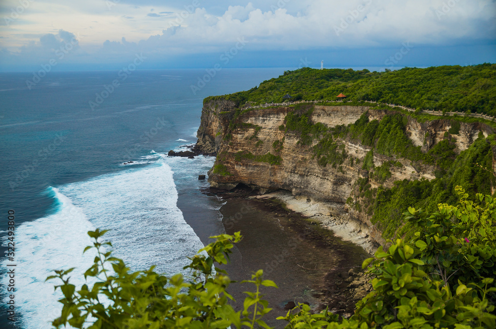 A beautiful ocean in Bali. The Pacific Ocean with large waves and tides that break on the rocks. The Indian Ocean is blue. Aqua Mente and Phantom Blue. Golden sunset on the ocean on the island of Bali