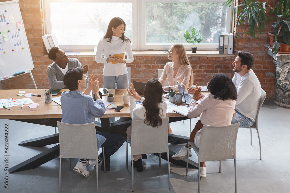 Asian lady making report in front of business team