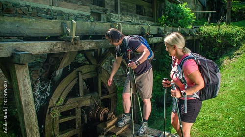 Man turning around an old water mill. sunny day, hiking in nature. Prevalje, Slovenia photo