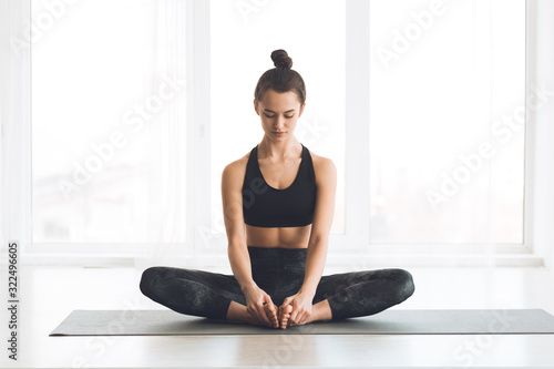 Woman sitting in butterfly position with bare feet