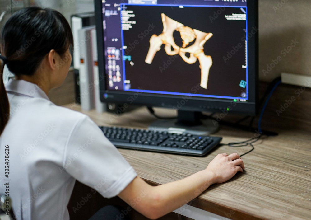 Radiotechnologist hand holding mouse while working on CT scan ...