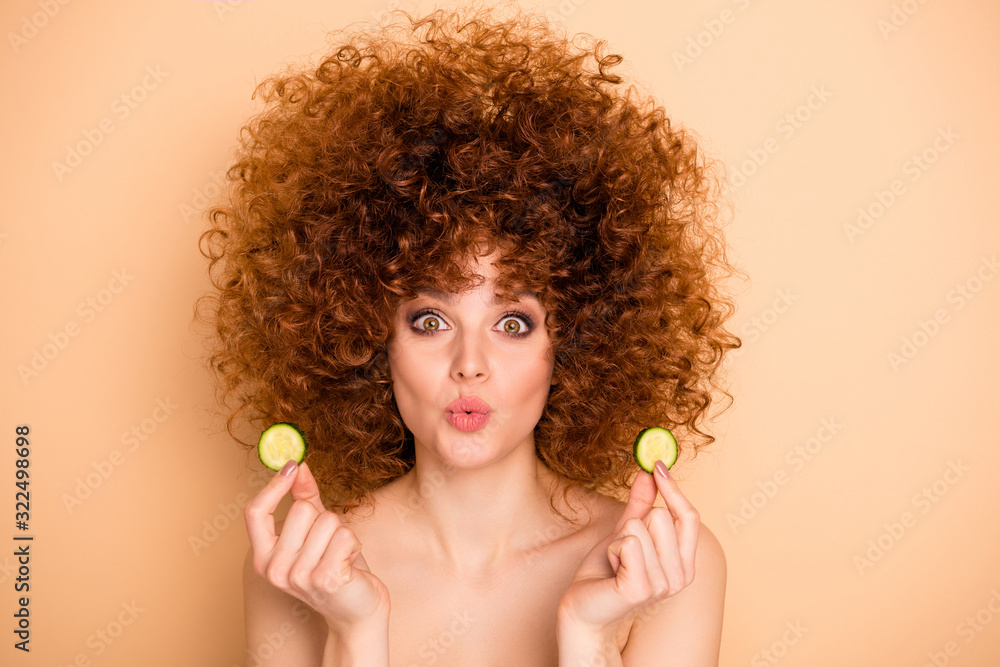 Close-up portrait of her she nice cute charming attractive cheerful cheery wavy-haired girl holding in hands cucumber pieces slices sending you air kiss isolated over beige pastel background