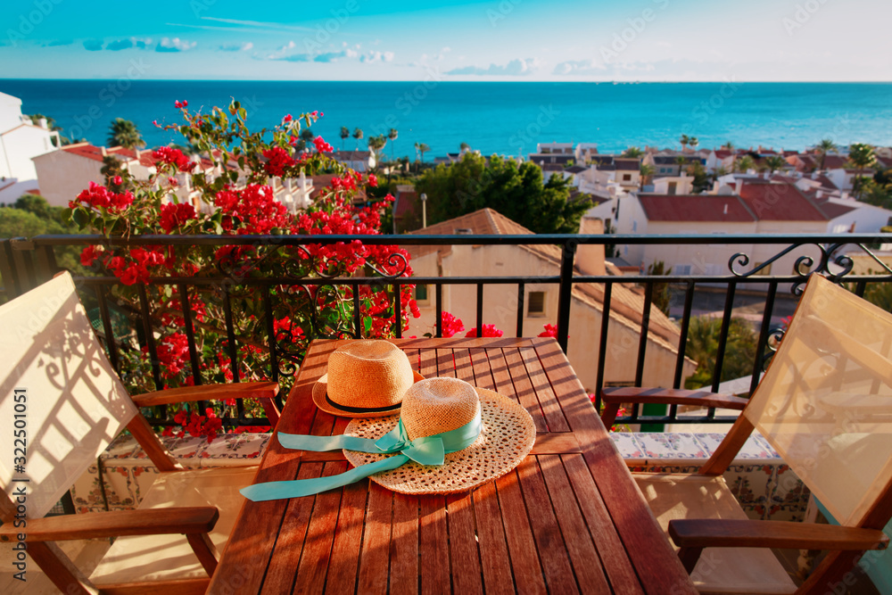 two hats on balcony terrace with sea view, travel concept