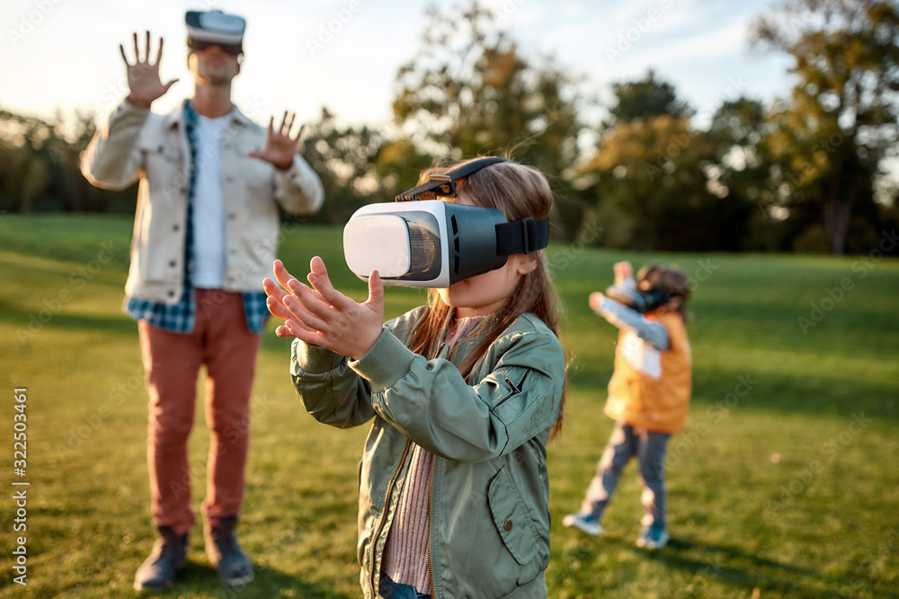 Something new. Family playing in virtual reality glasses outdoors Something new. Family playing in virtual reality glasses outdoors