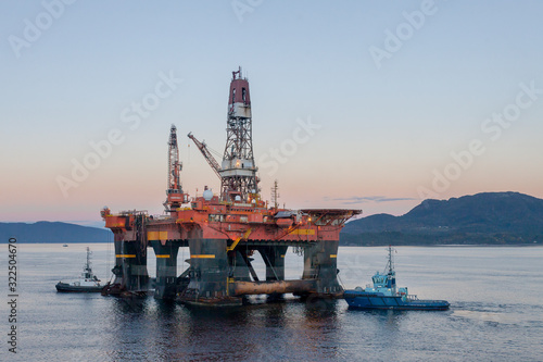 OELEN NORWAY - 2014 OCTOBER 16. The semi-submersible drilling rig West Alpha inside the Norwegian fjord in the morning with tug boats.