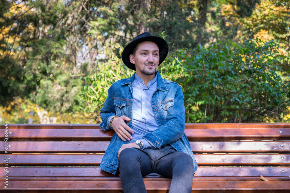 Portrait of a confident and successful young man with a denim jacket and blue shirt outside. Handsome young man outside. Happy guy smiling
