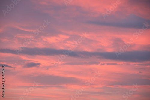 Dreamy evening sky in pastel tones with fluffy pink clouds at sunset