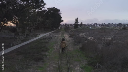 Woman walking on train rail drone view in Pedras del Rei, Portugal
