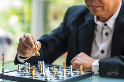 Business man holding The king chess for finishing the game