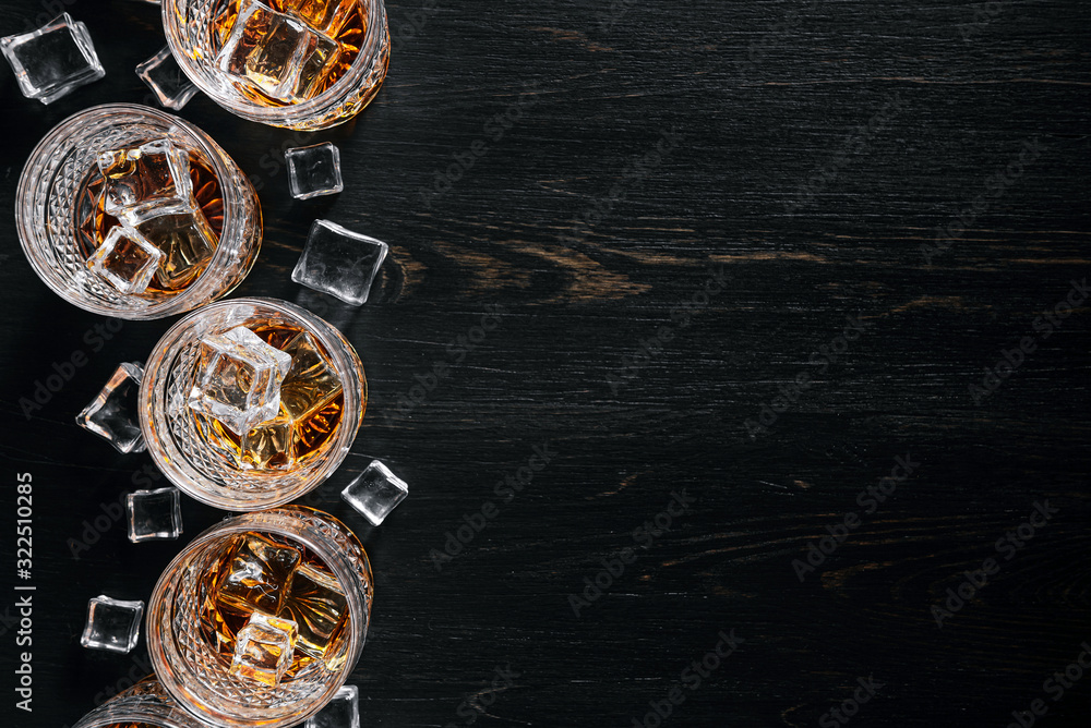 many glasses of whiskey with ice on a black table many glasses of whiskey with ice on a black table
