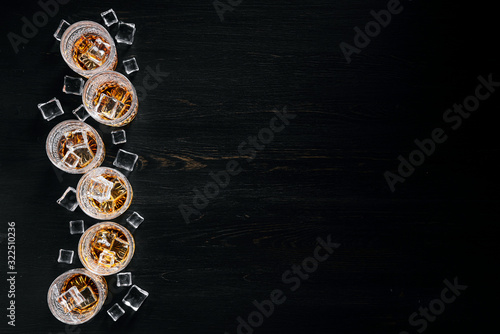 many glasses of whiskey with ice on a black table © Mikhaylovskiy 