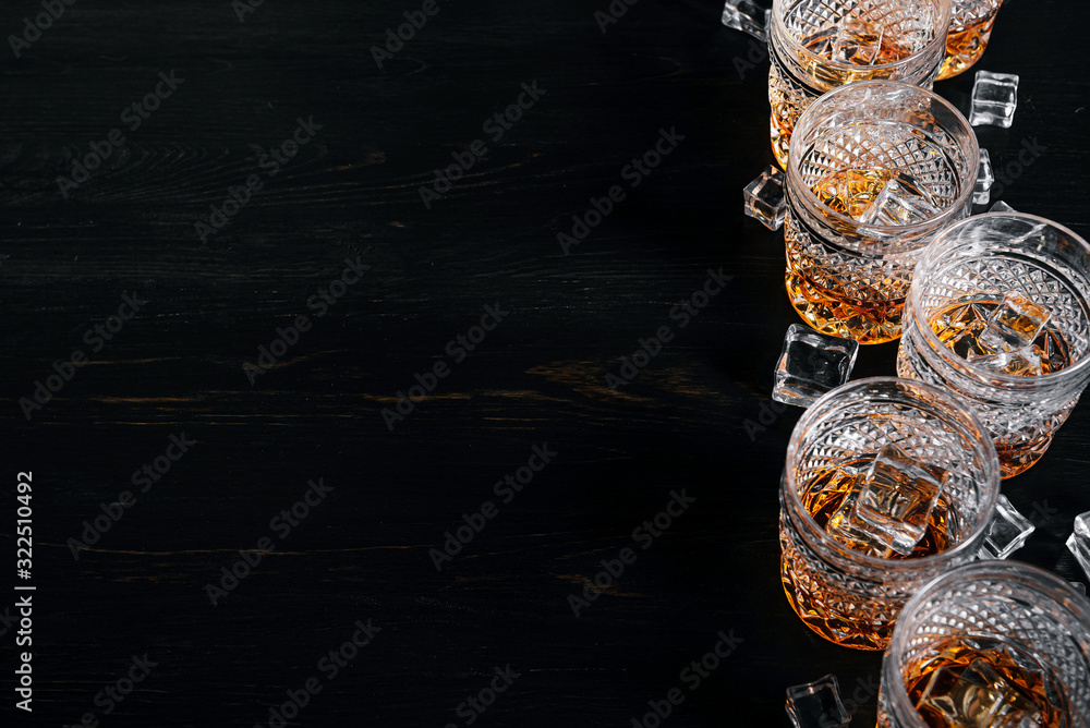 many glasses of whiskey with ice on a black table many glasses of whiskey with ice on a black table