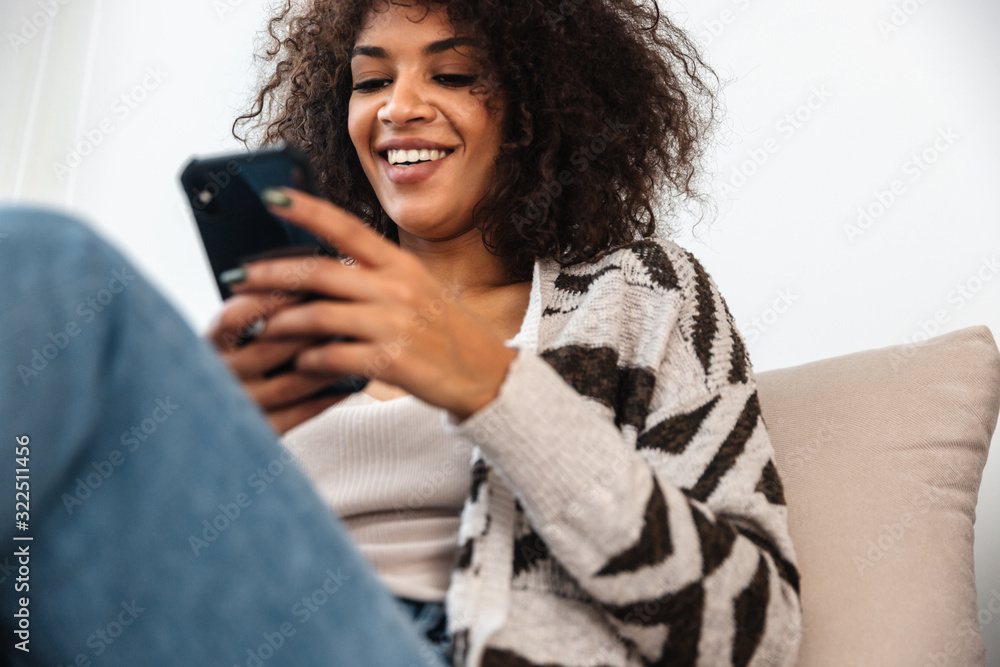 Woman indoors at home using mobile phone. Woman indoors at home using mobile phone.