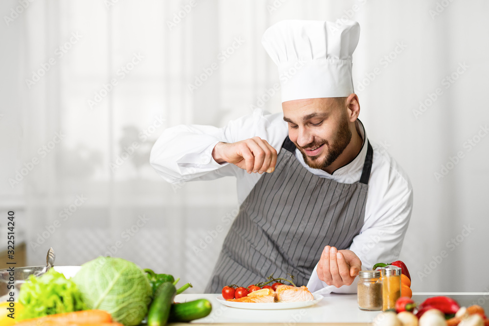 Male Chef Seasoning Roasted Salmon Steak In Kitchen Male Chef Seasoning Roasted Salmon Steak In Kitchen