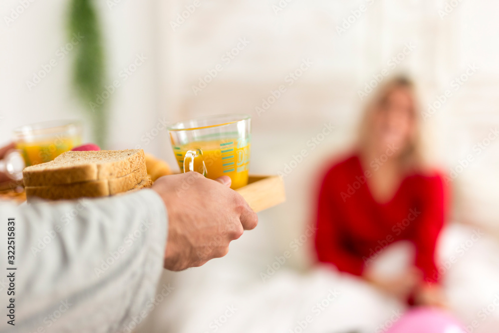 Man making a surprise breakfast in bed for his girlfriend Man making a surprise breakfast in bed for his girlfriend
