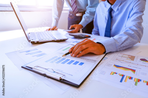 Two business man people working analyzing and calculate summary of cost from document chart and graph with calculator at office, Accounting and finance in the office.