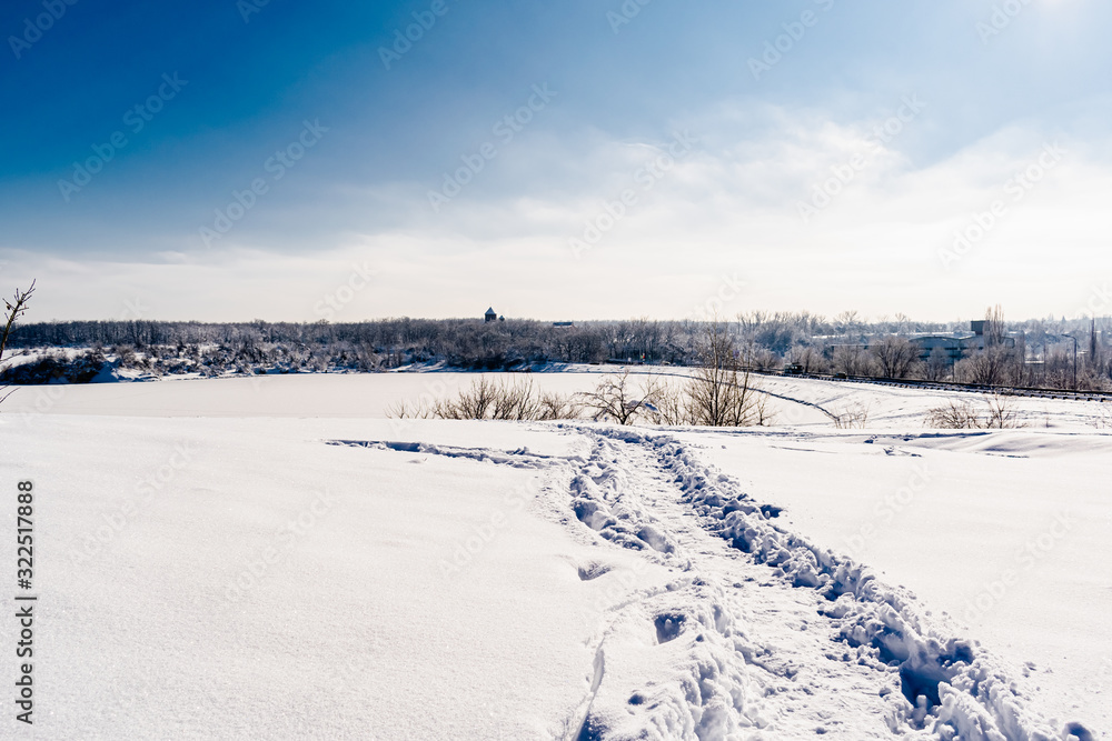 Spacious snow landscape. River and hills in Russia, white winter on the terrain, a lot of fluffy snow and ice under a beautiful blue sky. Rostov region, town of Shakhty, the river Grushevka