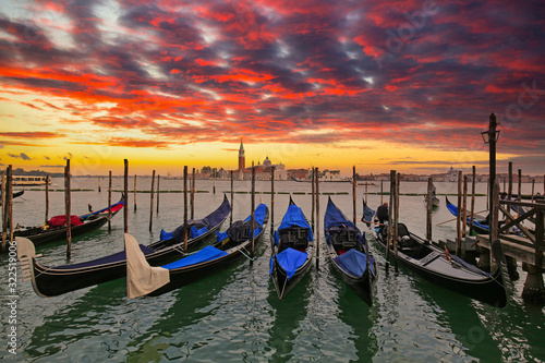 Venetian gondolas at the harbor and San Giorgio Maggiore island at sunset, Venice. Italy © Patryk Kosmider