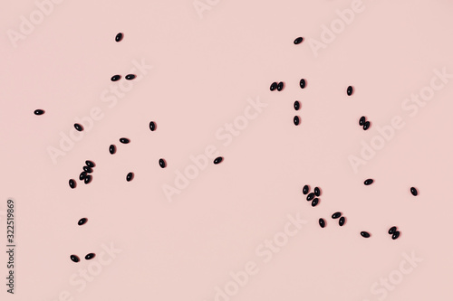 Scattered medical capsules on a pink background. Flat lay, top view, copy space.