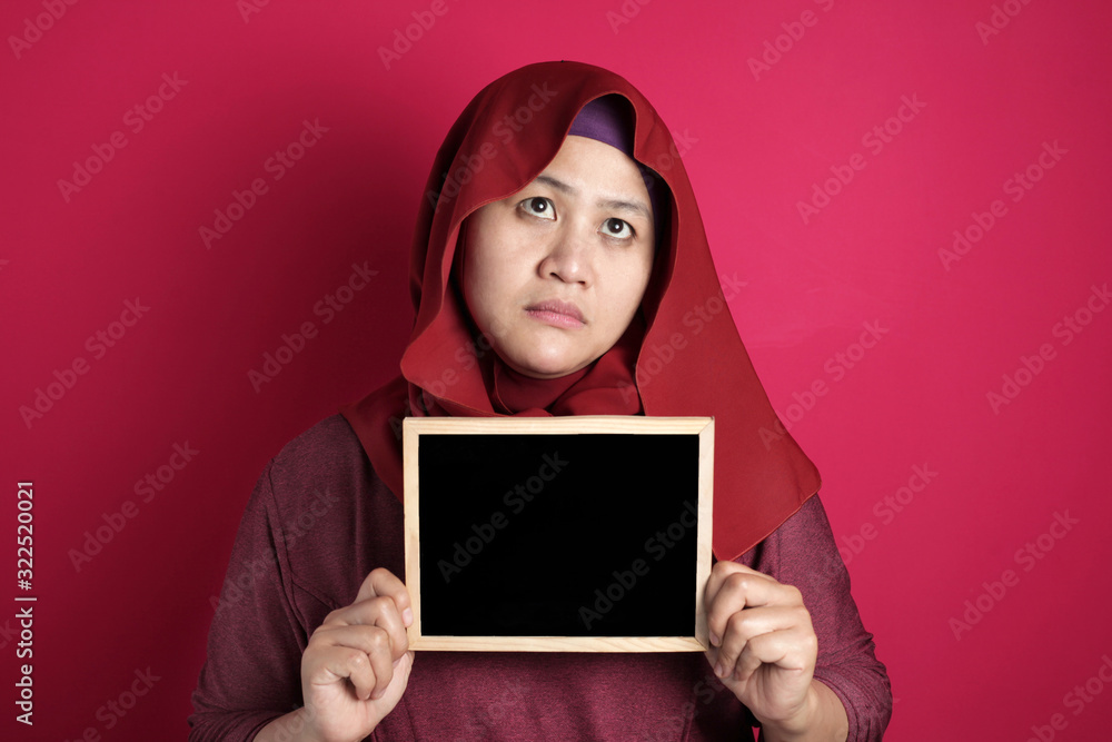 Bad mood angry annoyed Asian muslim woman shows empty blackboard Bad mood angry annoyed Asian muslim woman shows empty blackboard