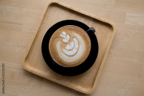 Cup of coffee latte on wooden background. Top view.
