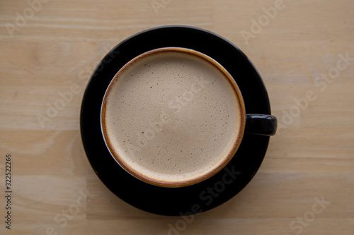 Cup of coffee latte on wooden background. Top view.