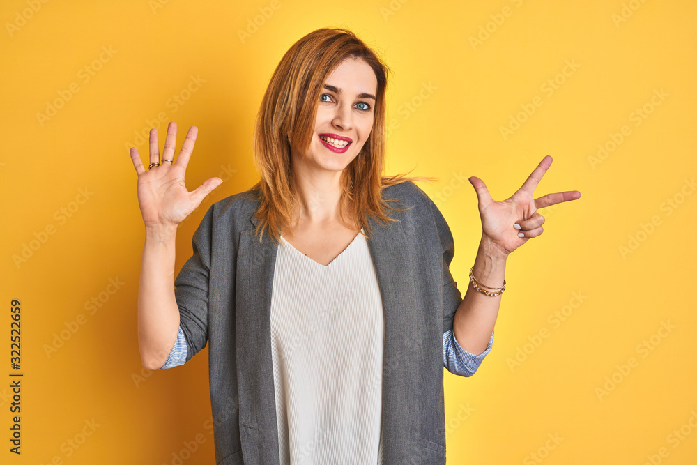 Redhead caucasian business woman over yellow isolated background showing and pointing up with fingers number eight while smiling confident and happy.