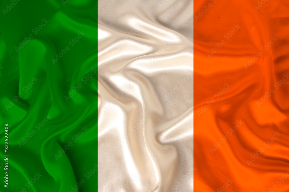 photo of the national flag of Ireland on a luxurious texture of satin, silk with waves, folds and highlights, closeup, copy space, travel concept, economy and state policy, illustration