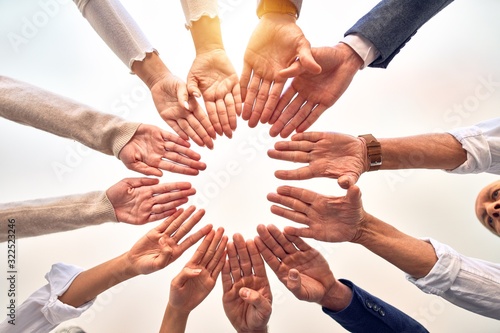 Group of business workers standing doing symbol with fingers together at the office