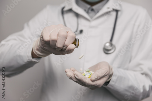 Close-up of male doctor giving too much pills. Overdose concept.