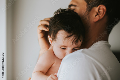 Closed shot of baby in his father's arms - family