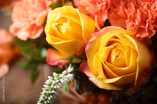 Yellow and orange roses bouquet on a rustic wooden background 