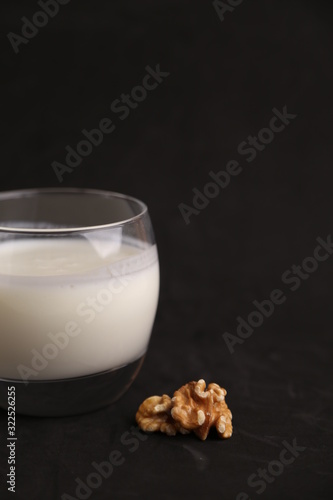 glass of walnut milk in color background