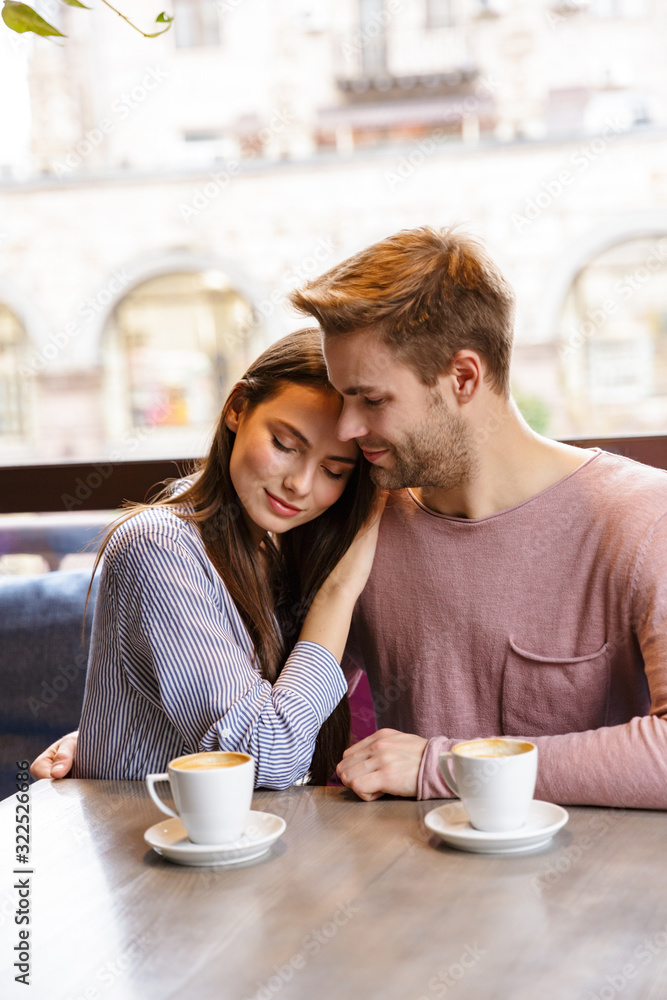 Attractive young couple having lunch at the cafe indoors Attractive young couple having lunch at the cafe indoors