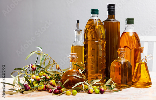 Different bottles with olive oil and olive branches