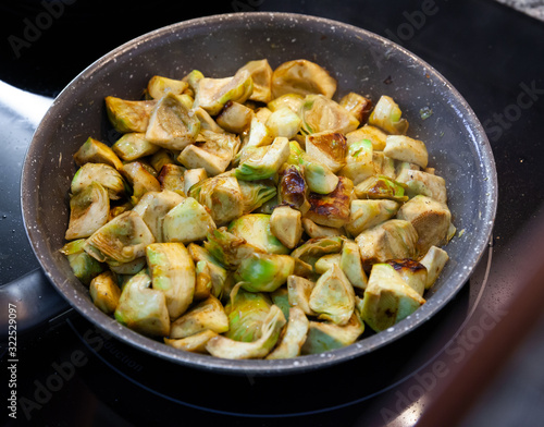 Appetizing artichokes fried in a pan
