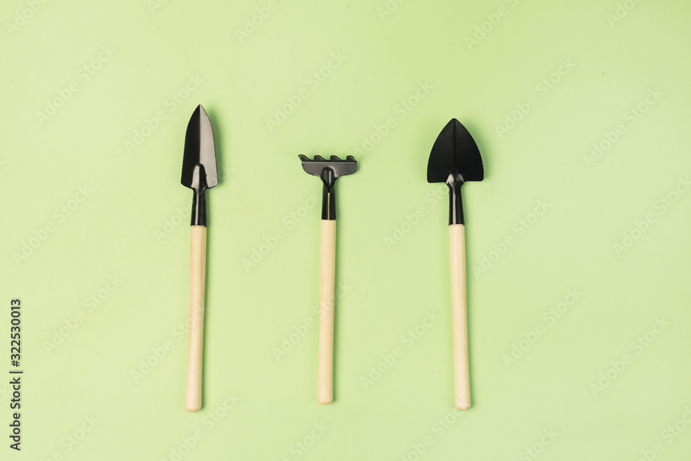 Garden Tools on Green Background Small Garden Rake and Garden Shovel Horizontal Top View Gardening Spring or Summer Concept Garden Tools on Green Background Small Garden Rake and Garden Shovel Horizontal Top View Gardening Spring or Summer Concept