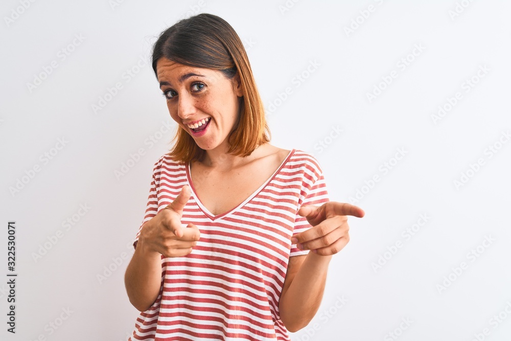 Beautiful redhead woman wearing casual striped red t-shirt over isolated background pointing fingers to camera with happy and funny face. Good energy and vibes. Beautiful redhead woman wearing casual striped red t-shirt over isolated background pointing fingers to camera with happy and funny face. Good energy and vibes.
