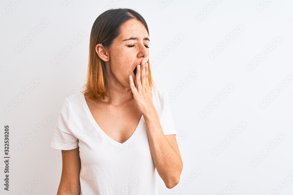Beautiful redhead woman wearing casual white t-shirt over isolated background bored yawning tired covering mouth with hand. Restless and sleepiness. Beautiful redhead woman wearing casual white t-shirt over isolated background bored yawning tired covering mouth with hand. Restless and sleepiness.