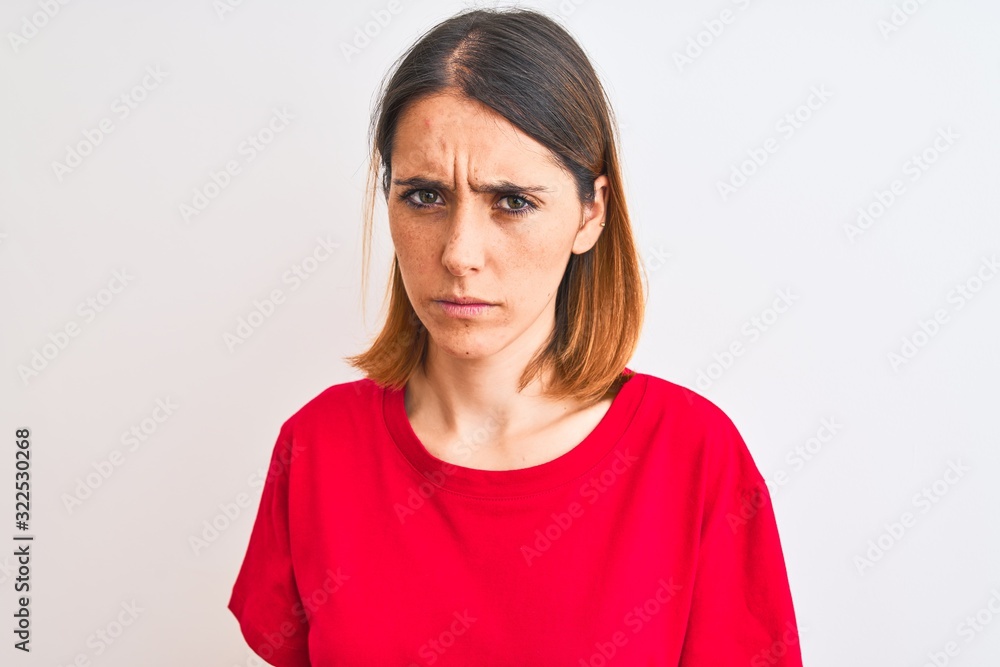 Beautiful redhead woman wearing casual red t-shirt over isolated background skeptic and nervous, frowning upset because of problem. Negative person. Beautiful redhead woman wearing casual red t-shirt over isolated background skeptic and nervous, frowning upset because of problem. Negative person.