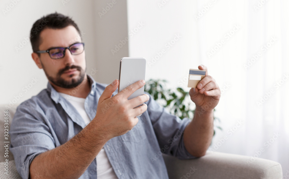 Young man buying fashion items through the Internet Young man buying fashion items through the Internet