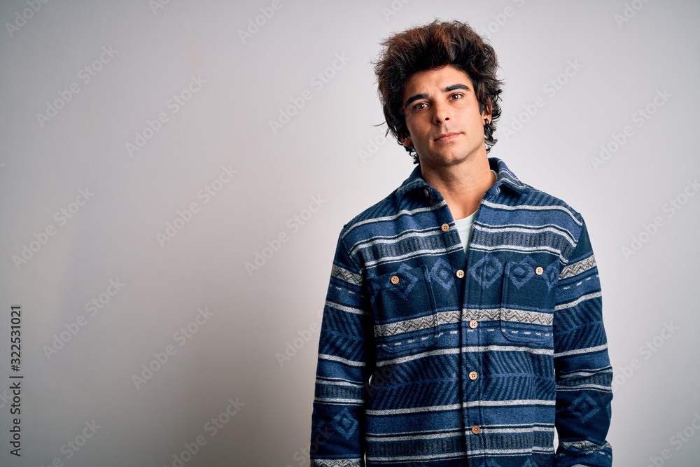 Fototapeta premium Young handsome man wearing casual shirt standing over isolated white background Relaxed with serious expression on face. Simple and natural looking at the camera.