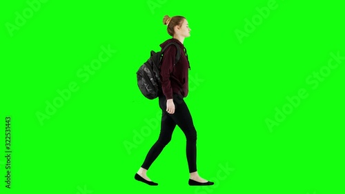Casual Woman in a Sweatshirt Walking With a Backpack on Green Screen