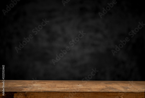 Wood table and black concrete wall background. can be used to install the product.